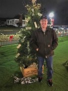 Picture of Dan Gesell in front of a Christmas Tree.
